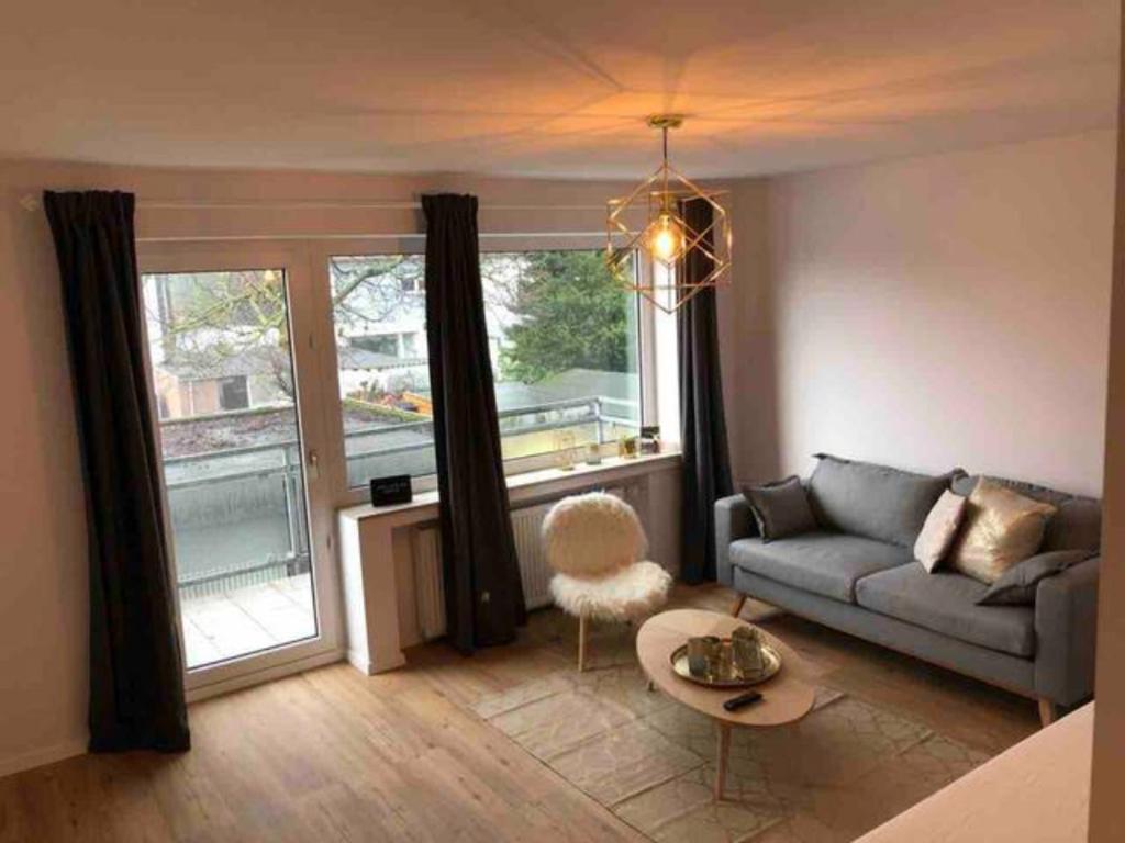奥伯豪森Sanierte 2 Zimmer Wohnung am CentrO in Oberhausen的带沙发和大窗户的客厅