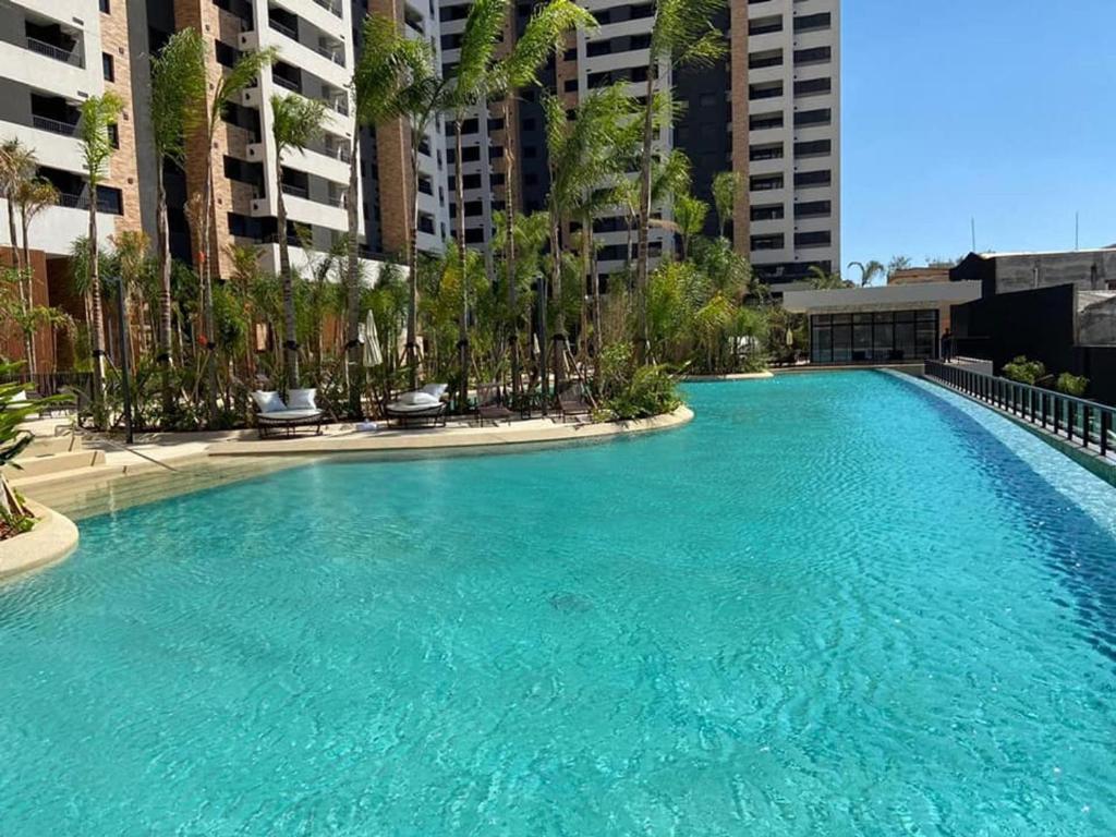 圣保罗Piscine Resort Brás的一座棕榈树和建筑的大型游泳池