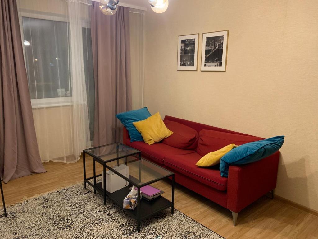 维尔纽斯Cosy apartment near downtown and airport的客厅配有红色沙发,提供蓝色和黄色枕头