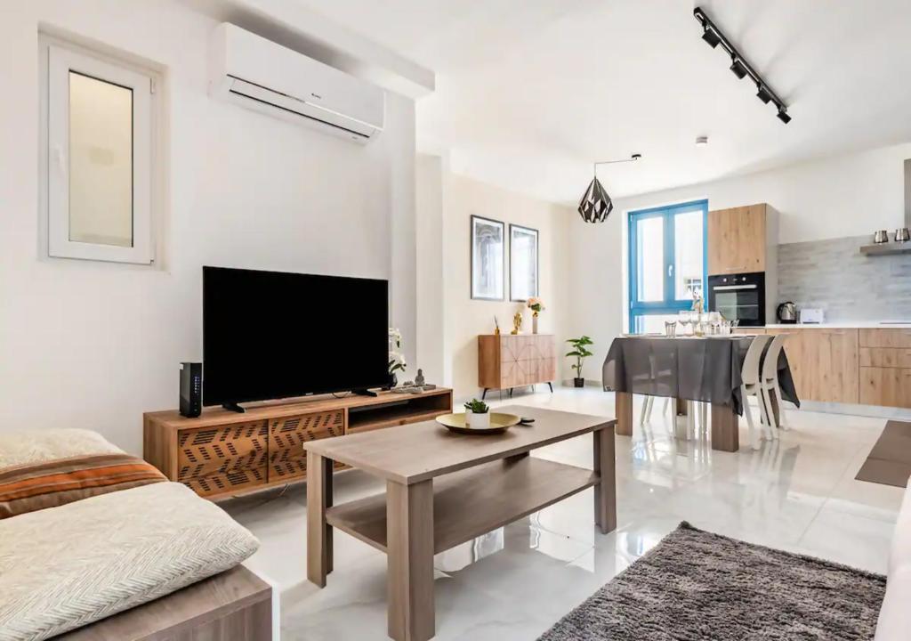 瓦莱塔Sea View Luxury Apartment Brand New in Valletta的客厅配有平面电视和桌子。