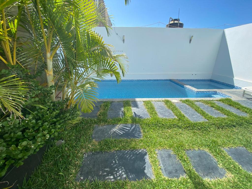 帕拉卡斯Killamoon House Paracas的后院设有游泳池和草地