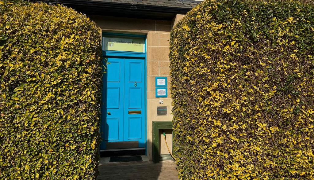 爱丁堡剑桥酒店的两丛之间建筑物中的一扇蓝色门