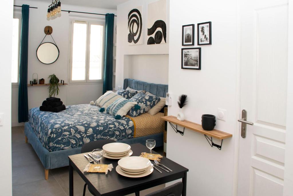 马赛Au Pied du Vieux-Port Wifi Netflix的一间卧室配有床和一张桌子,上面有盘子