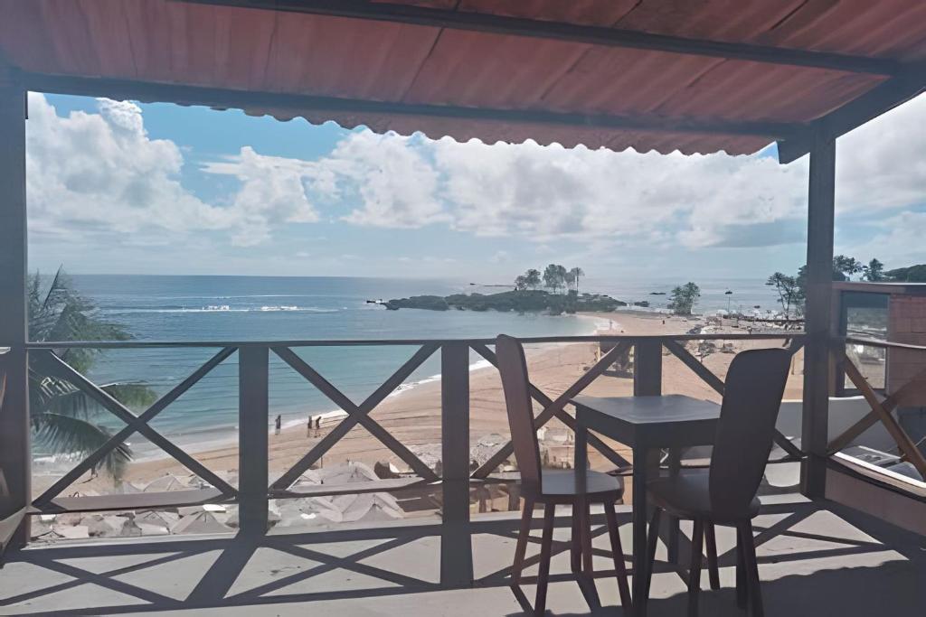 凯鲁Flats Nascer do Sol的一个带桌椅和海滩的阳台