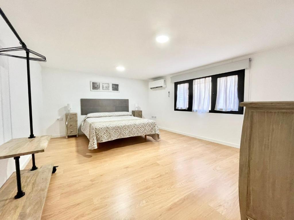 比利亚霍约萨Duplex zona centro的一间卧室配有一张床,铺有木地板