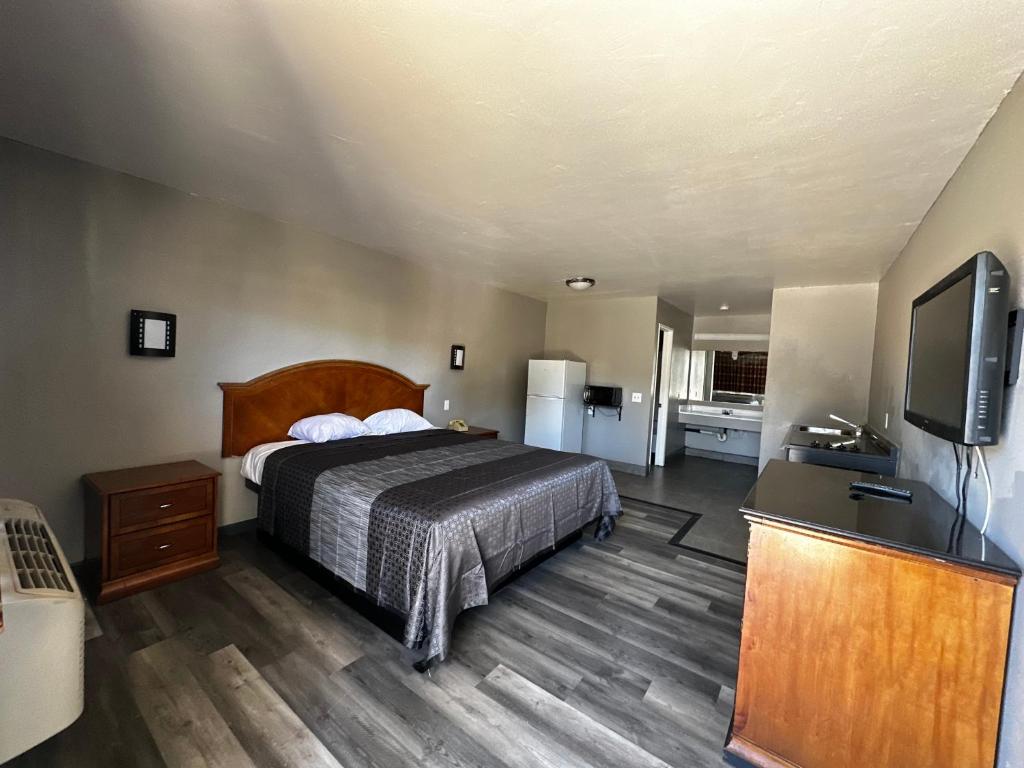 圣贝纳迪诺朝阳公园旅馆&套房的一间卧室配有一张床和一台平面电视