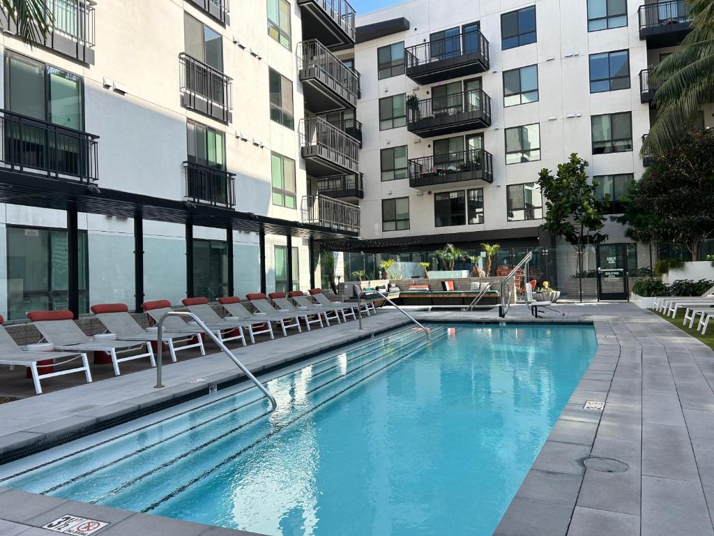 洛杉矶APARMENT IN SUNSET的一座带椅子的游泳池以及一座建筑