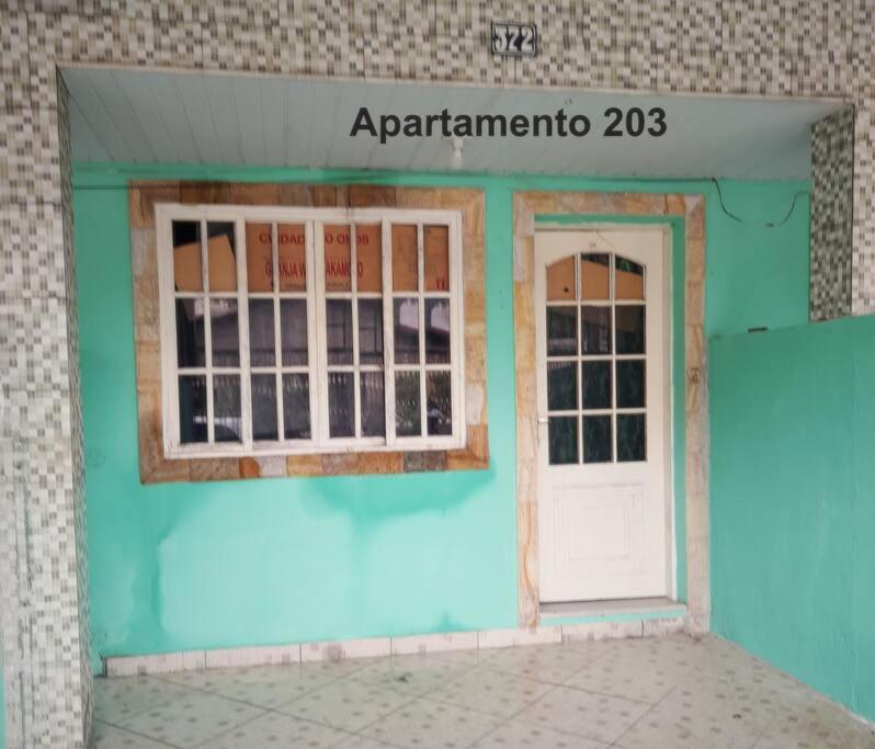 曼加拉蒂巴Apartamento em Muriqui/RJ - apt 203的蓝色的建筑,设有门窗