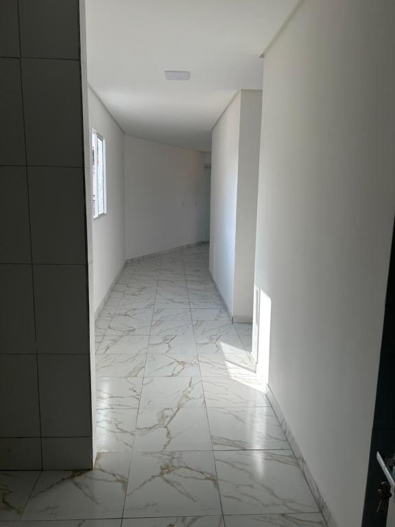 奥林达Casa união的空的走廊,有白色的墙壁和白色的瓷砖地板