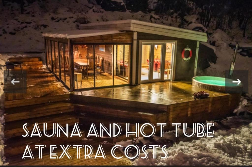 HolmestrandSea view Holmestrand sauna and hot tube appartment的甲板上带热水浴池的房子