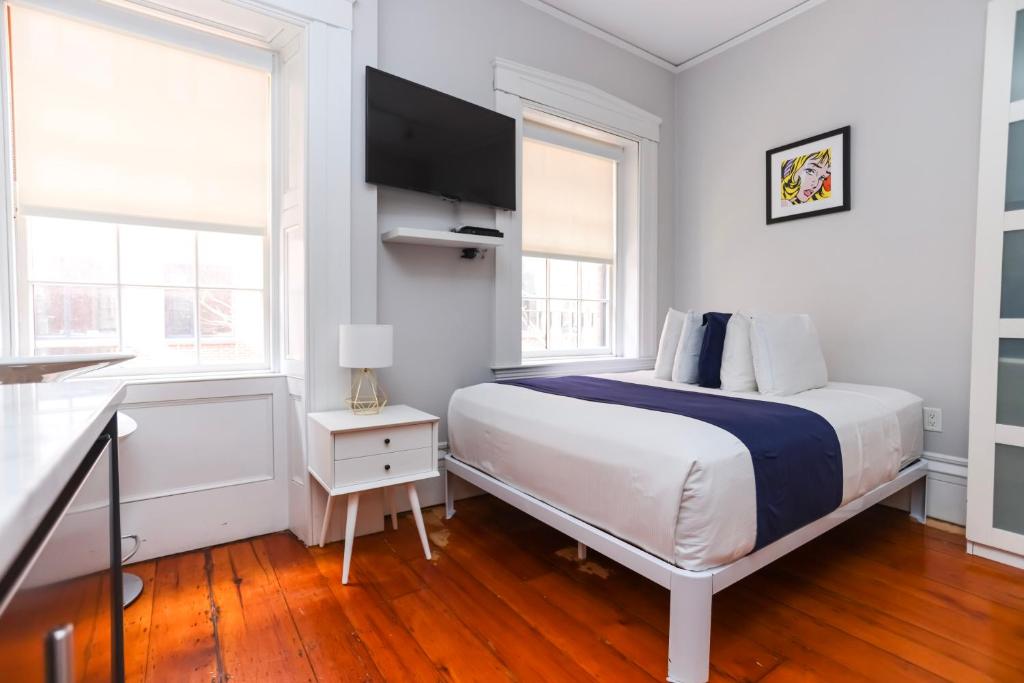 波士顿Charming & Stylish Studio on Beacon Hill #12的一间白色卧室,配有床和2个窗户