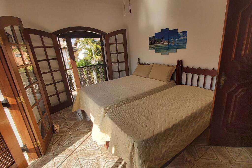 瓜鲁雅Castelinho do Felix Guarujá Pernambuco的一间卧室设有两张床和一扇开放式门