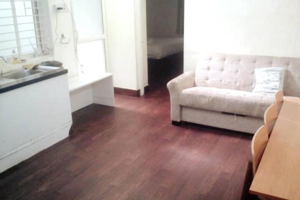 班加罗尔Clover Suites - Studios at Koramangala 4th block的带沙发和木地板的客厅