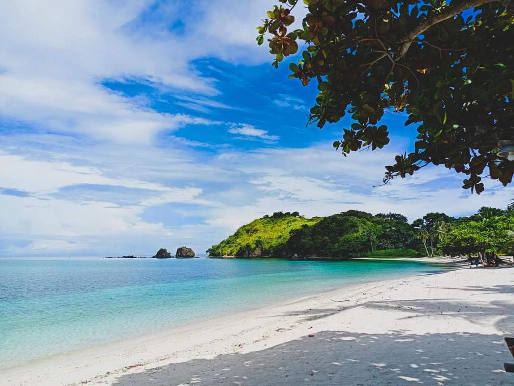 RomblonAglicay Beach Resort的菲律宾的海滩,以岛屿为背景