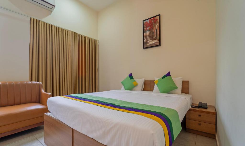 埃尔讷古勒姆Itsy By Treebo - Avani Stays - Vyttila, Kochi的一间卧室配有一张大床和一把椅子