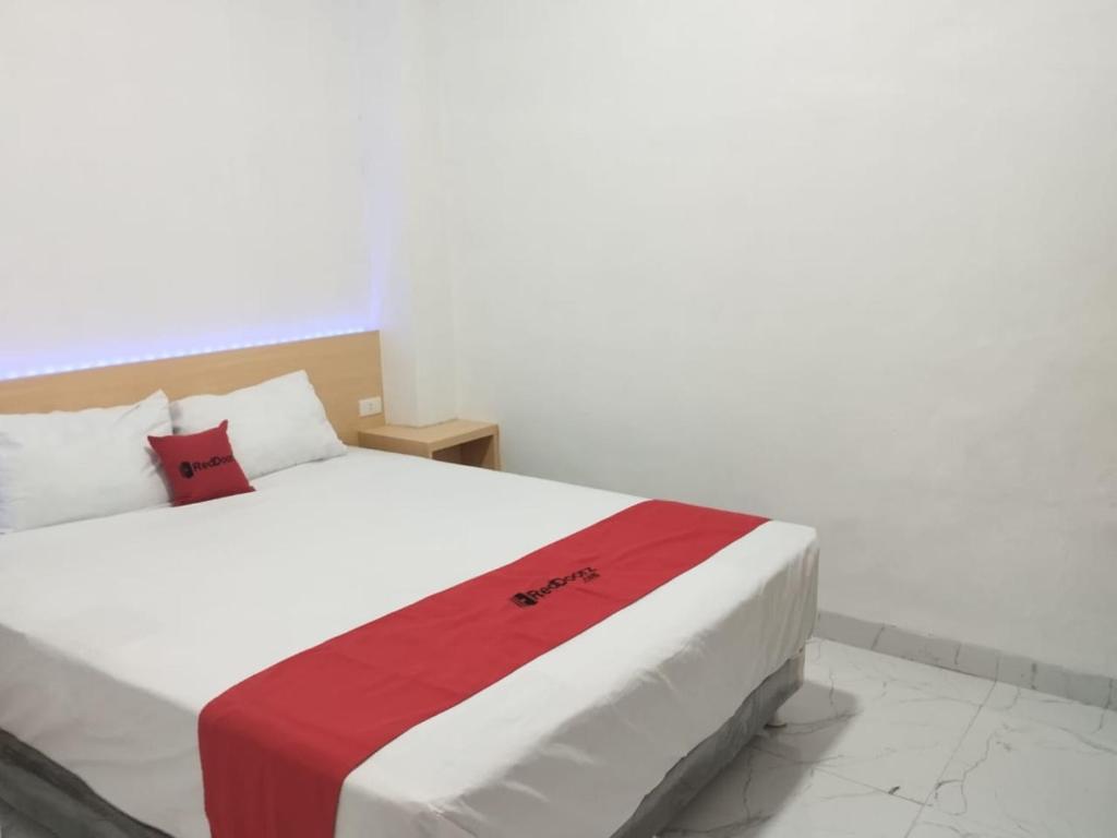 KedatonRedDoorz Syariah @ Gedong Air Lampung的一间卧室配有一张带红白毯子的床