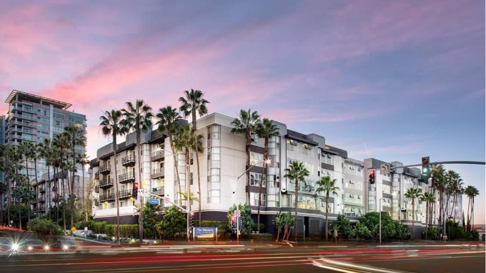 洛杉矶Villa Marina - Modern & Immaculate, Spacious, Gated Condo with Fireplace Pool, Gym, 2 Master Bedrooms的街道前方有棕榈树的建筑