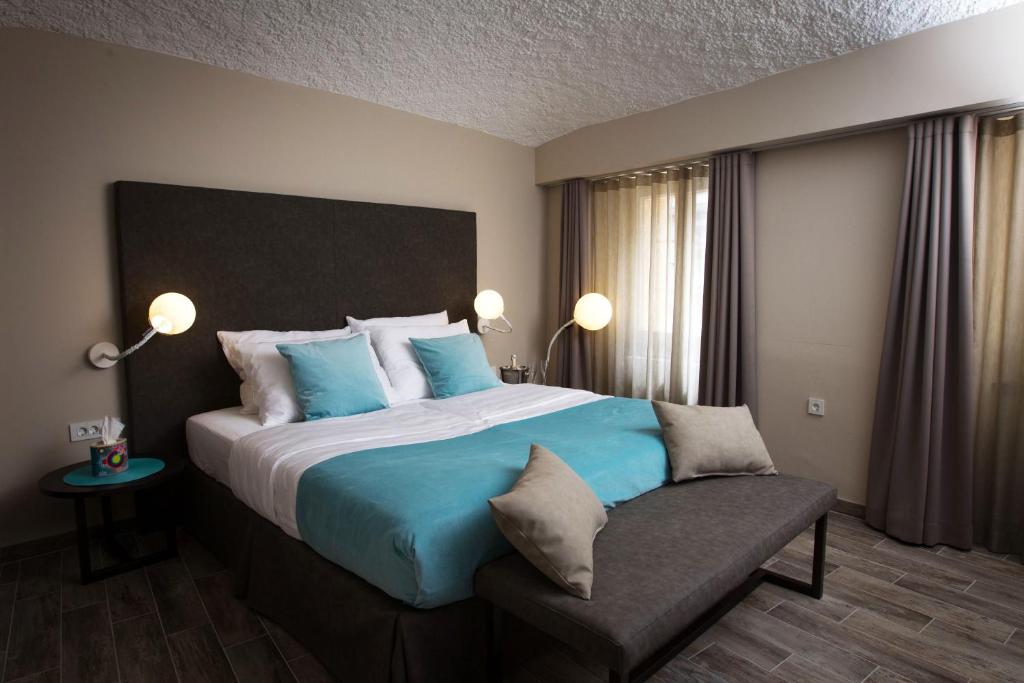 卢布尔雅那可可旅馆的一间卧室配有一张带蓝色枕头的大床