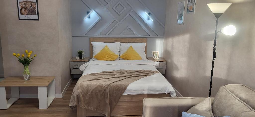 乌斯季卡缅诺戈尔斯克Lux Home Astana的一间卧室配有一张带黄色枕头的床和一张沙发。