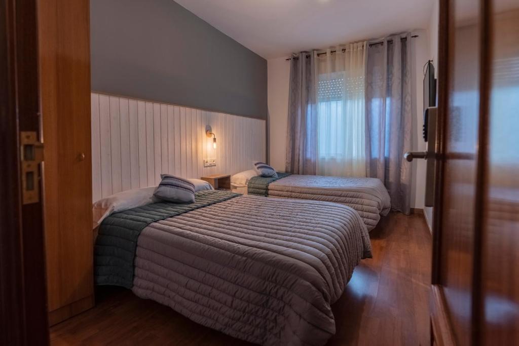 维尔根德尔卡米诺Hostal Julio Cesar的酒店客房设有两张床和窗户。