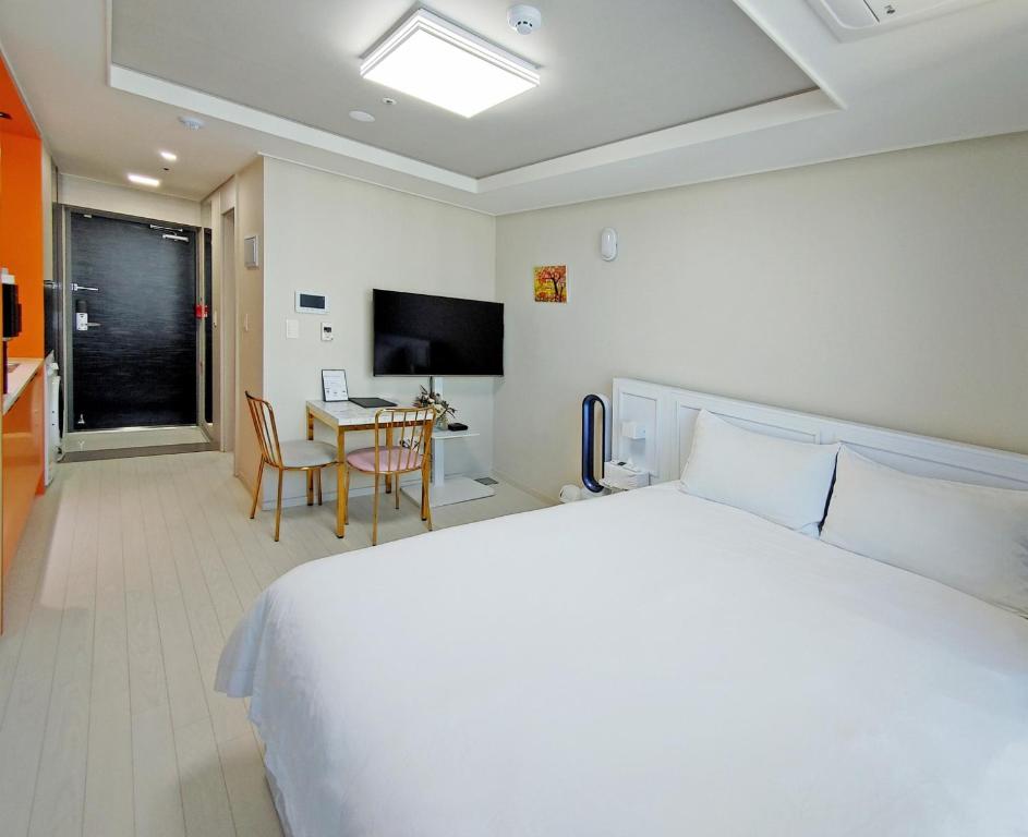 大邱Daegu Dongseongro Star B&B business hotel的一间卧室配有一张床、一张桌子和一台电视