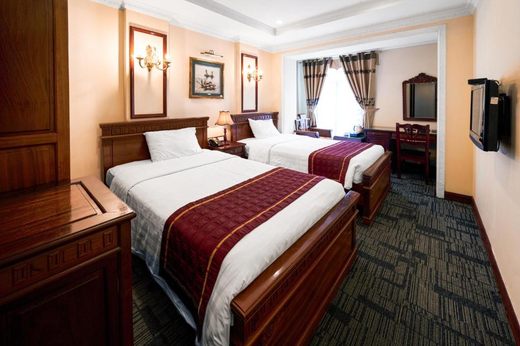 河内EDEN HOTEL HÀ NỘI的酒店客房设有两张床和电视。