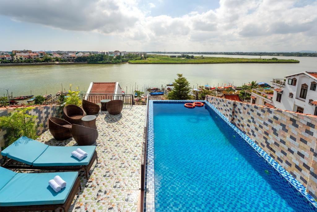 会安Rockmouse Centre River Villa Hoi An的游泳池位于河边的建筑物顶部
