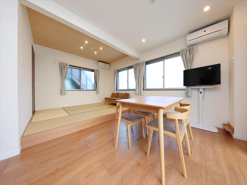 东京东京古都涩谷4公寓的用餐室配有桌椅和平面电视。