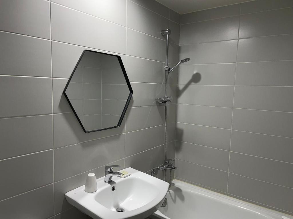 大田Hotel Stay Q的浴室配有盥洗盆、镜子和浴缸