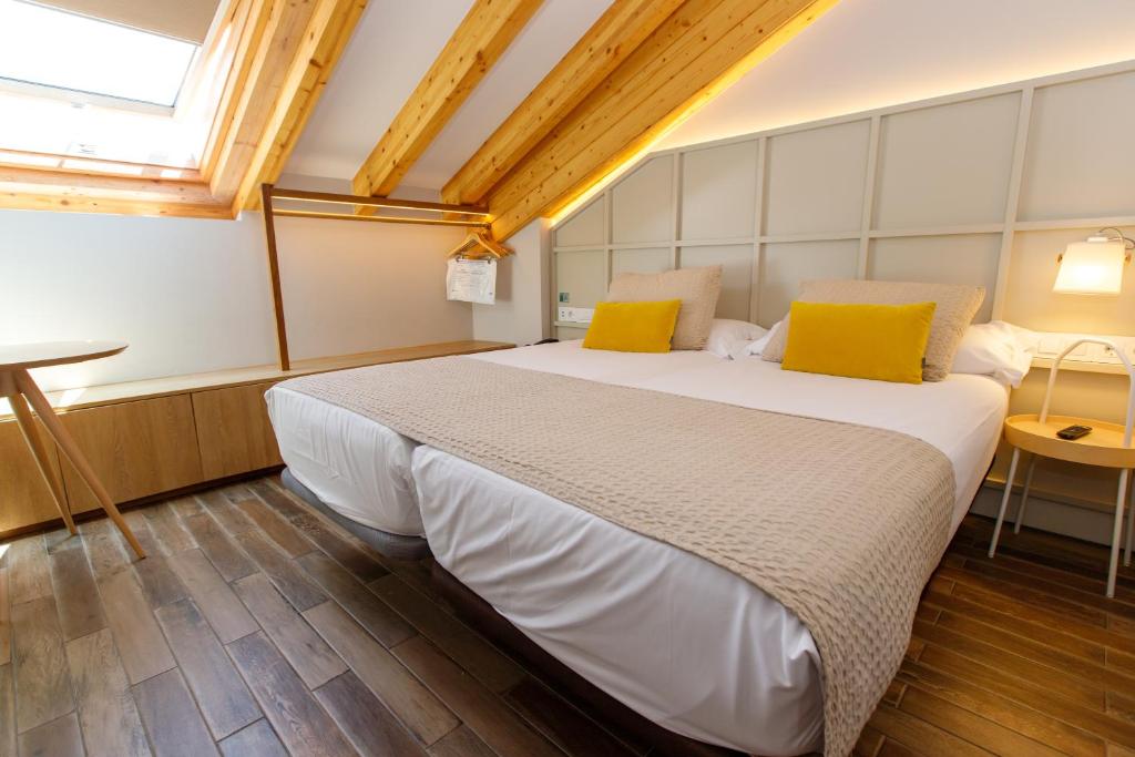 卡尔达斯·德·雷斯Hotel Pousada Real的卧室配有一张带黄色枕头的大型白色床。