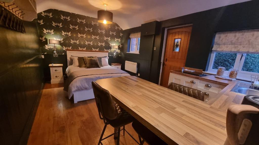 奥尔斯特Bijou Malthouse的一间卧室配有一张床和一张木桌
