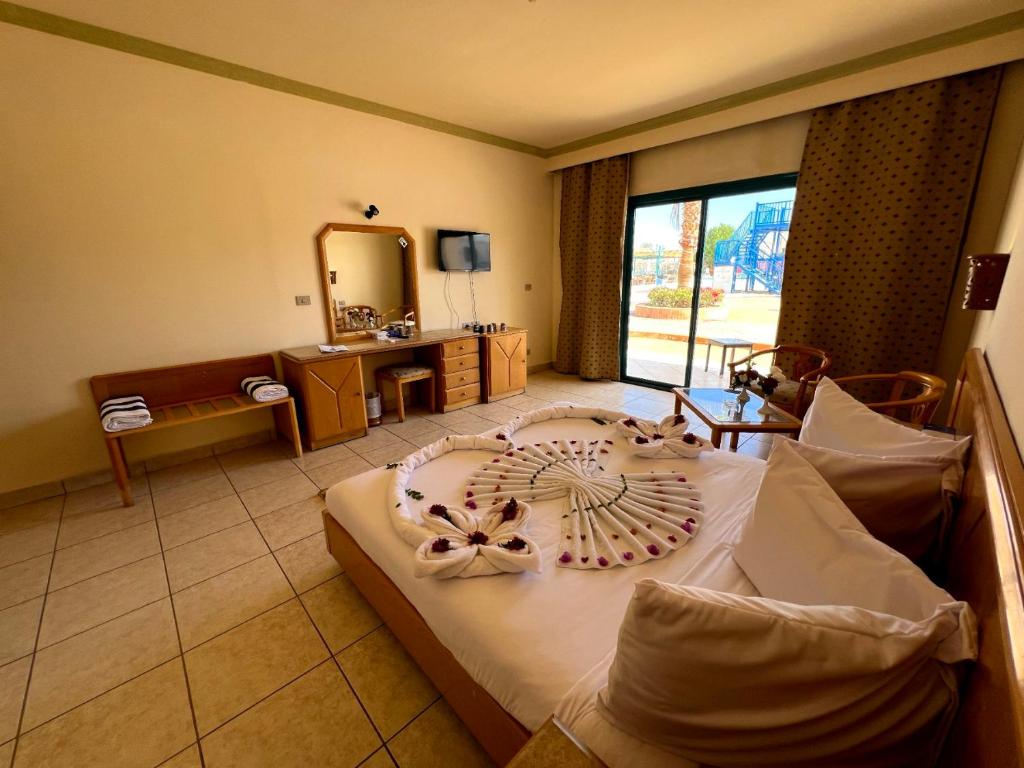 沙姆沙伊赫Sharm Cliff Hotel的一间卧室配有一张大床和大镜子