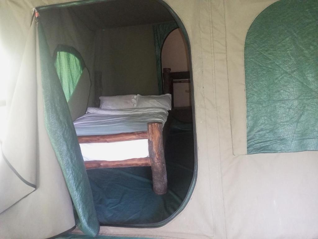  Kibale Forest National ParkKibale Tented Camp的帐篷内一间卧室,配有一张床