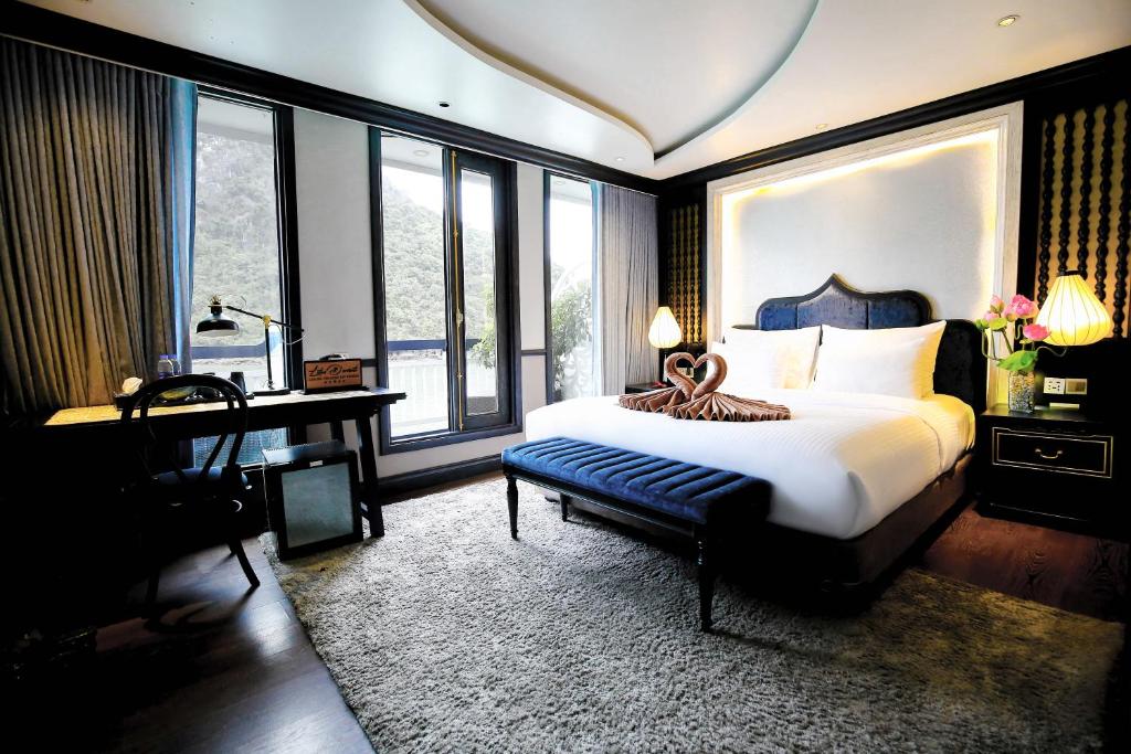 下龙湾Lotus D'Orient Cruise的卧室配有一张床、一张书桌和窗户。
