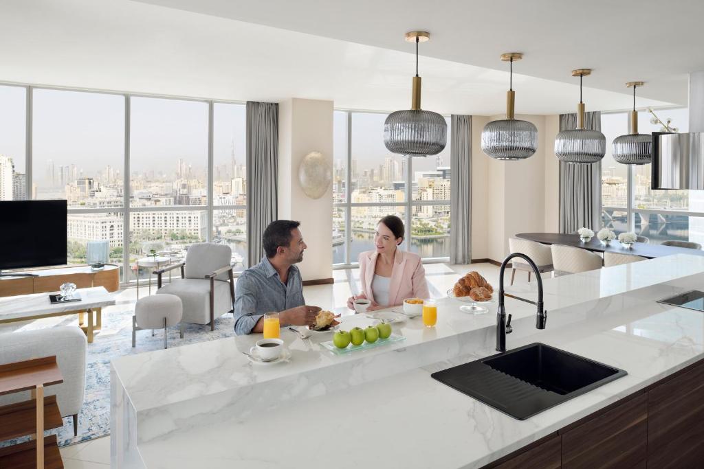迪拜迪拜节日城洲际公寓套房酒店 的坐在厨房里的男人和女人