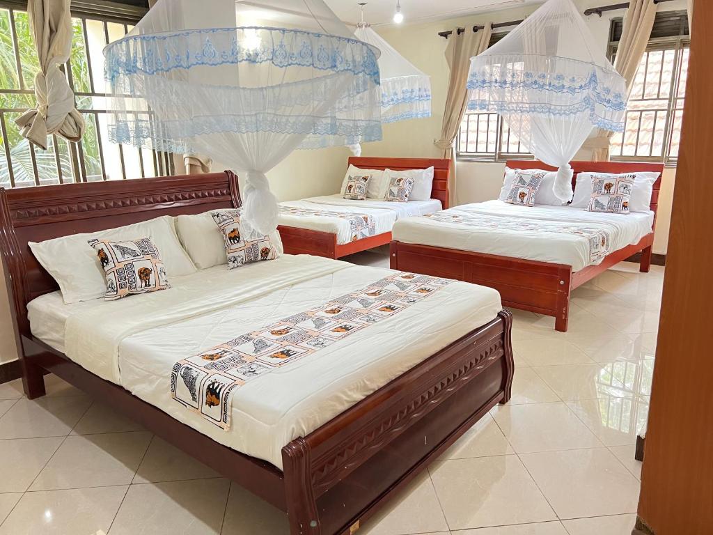 恩德培Victoria Rock Resort的一间带三张床的卧室,位于带窗户的房间内