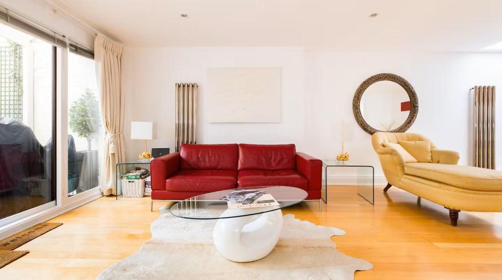 伦敦Notting Hill Luxury Duplex的客厅配有红色的沙发和椅子