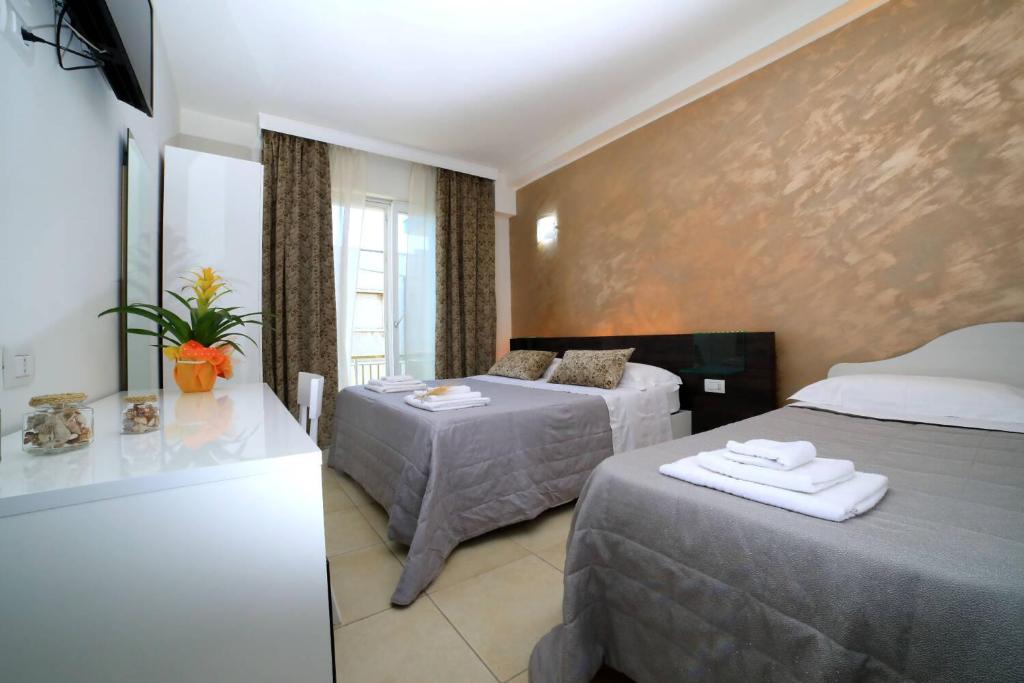 切萨雷奥港Palazzo Greco B&B的酒店客房设有两张床和窗户。
