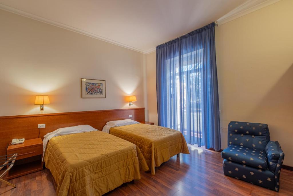 罗马Hotel Monte Verde的酒店客房,配有两张床和椅子