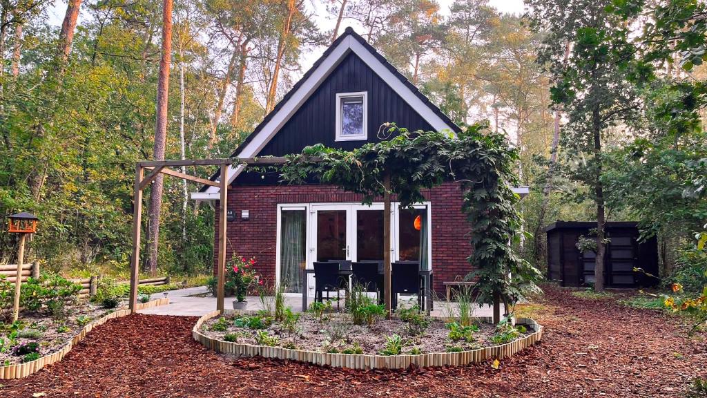 宁斯佩特Vakantiehuis Vliegend Hert Veluwe的前面有花园的小房子