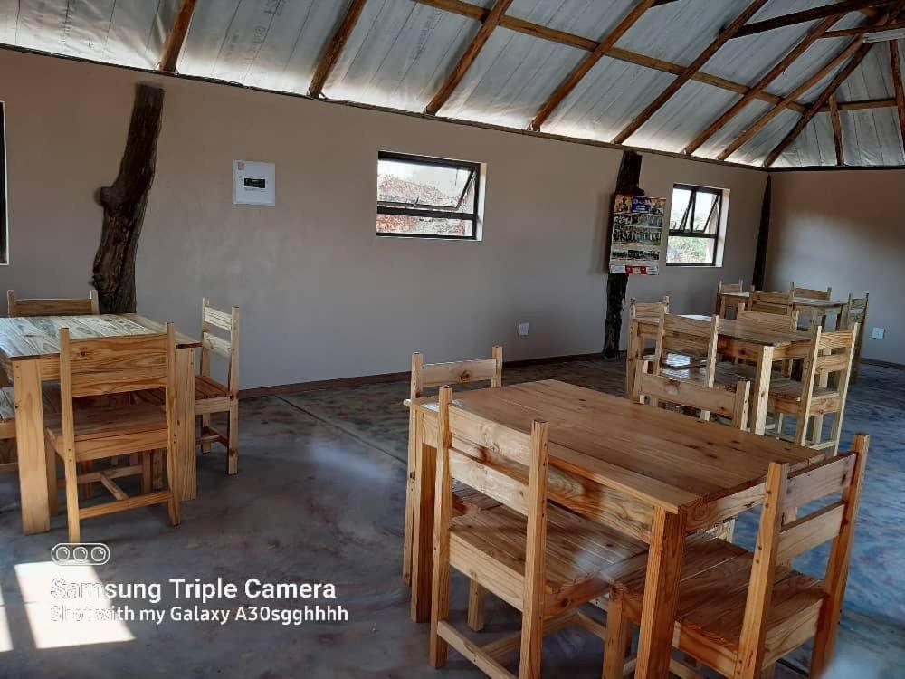 曼齐尼Inkwazi Getaway Lodge的用餐室配有木桌和椅子