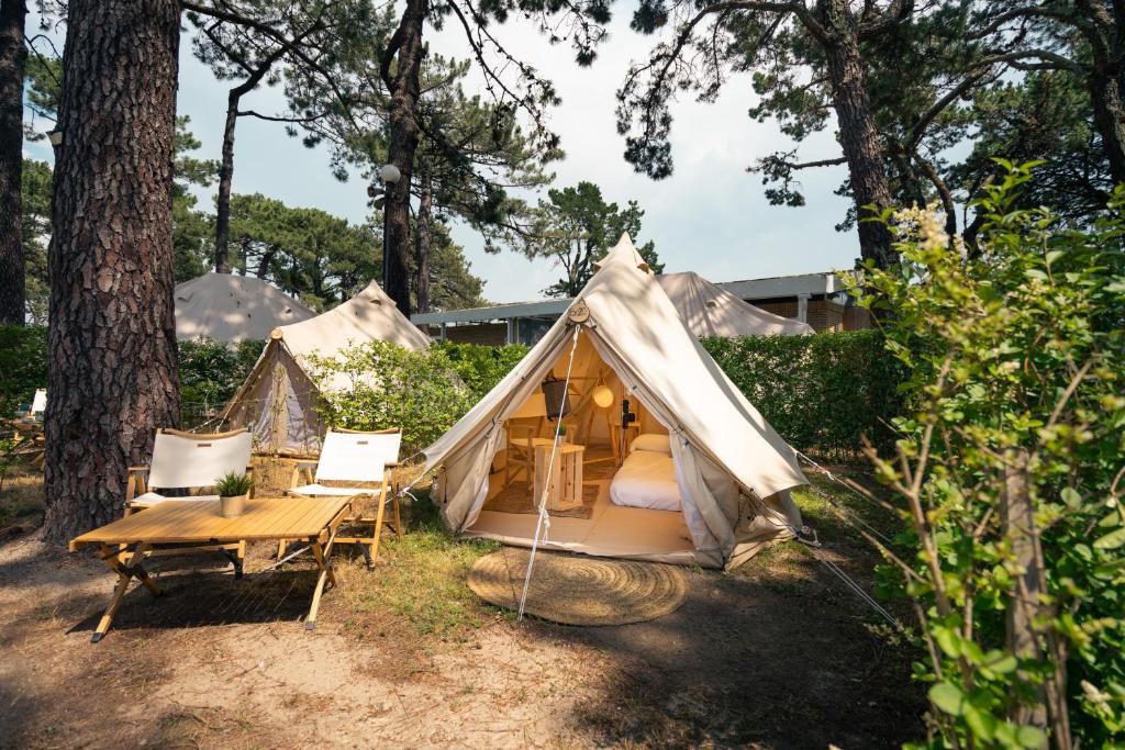巴约讷Kampaoh Bayona Playa的庭院内带桌椅的帐篷
