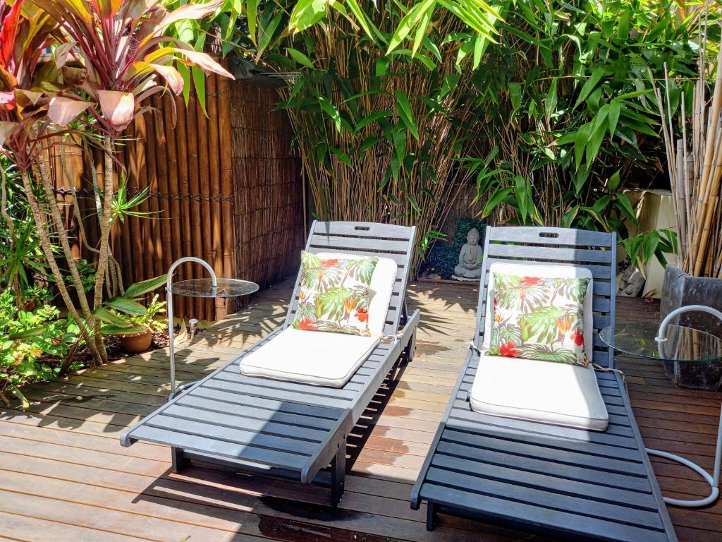 克罗纳拉Palm Garden Villa-Apt - Tropical Oasis at Cronulla Beach的甲板上配有两张蓝色椅子和枕头