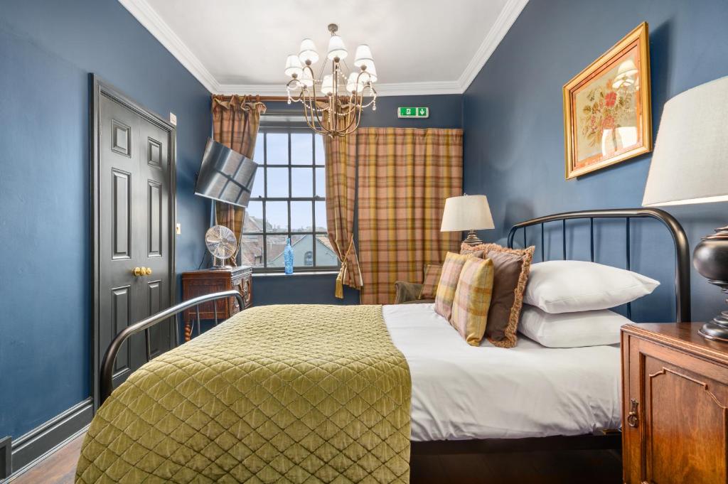 约克Guy Fawkes Inn的蓝色的卧室设有床和窗户
