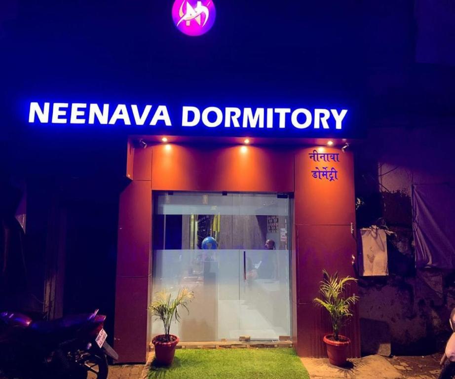 孟买Neenava Dormitory Asalpha的夜间一家新娘甜甜圈店的标志