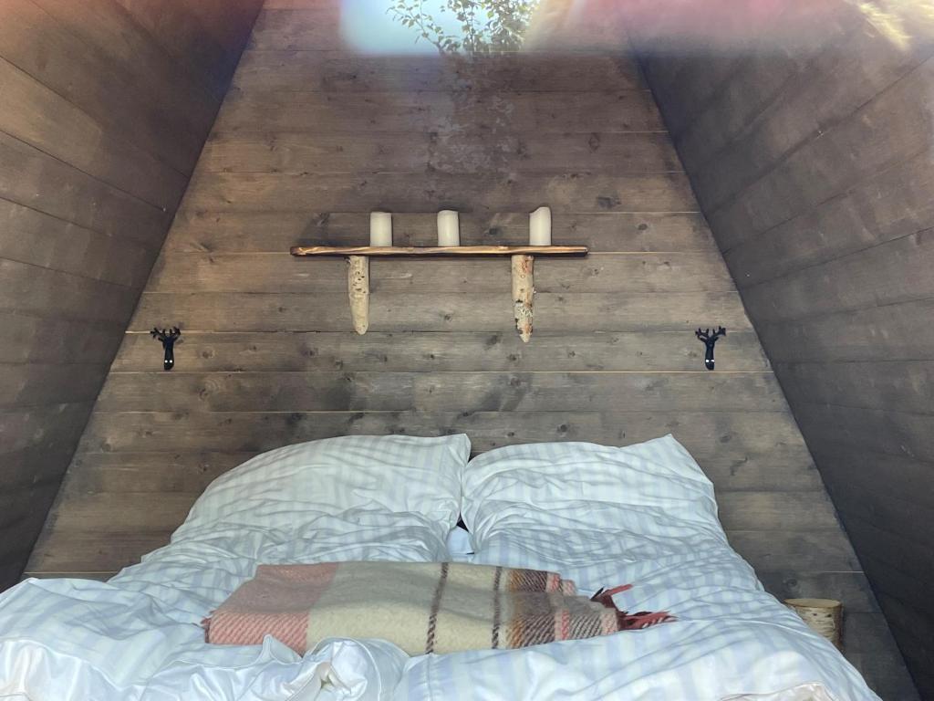 BorgafjällGlamping wooden house的一张位于带架子和蜡烛的房间的床铺