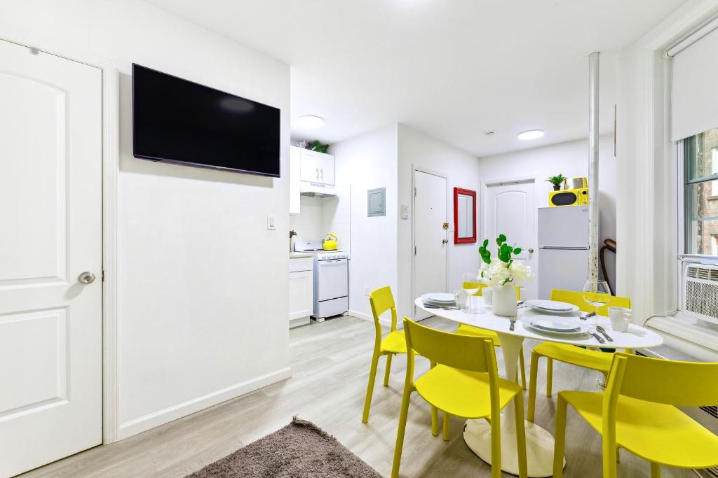 纽约Peaceful Apartment in Lower Manhattan New York的厨房以及带桌子和黄色椅子的用餐室。