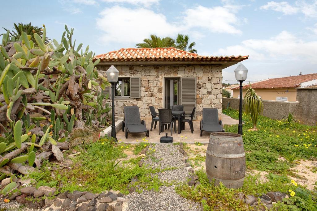 圣港Casa Do Vinho的庭院内带桌椅的石头房子