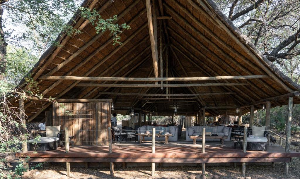 LentswelemoritiMashatu Tent Camp的一个带桌椅的大型木制凉亭