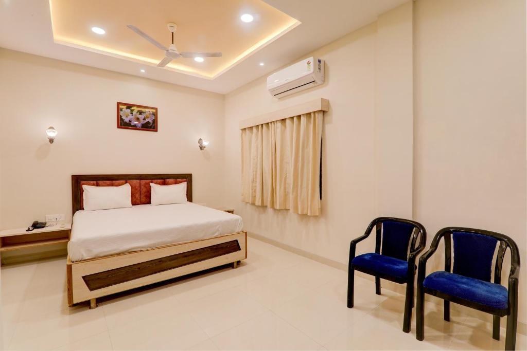 巴特那OYO Hotel Ambika Palace的一间卧室配有一张床和两张蓝色椅子